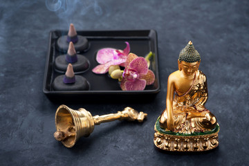Spa with statue Buddha, zen black stones, orchid and incense