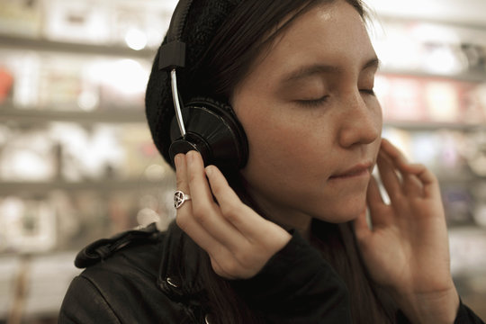 Young woman listening to music in a record store