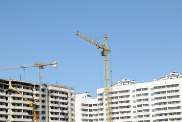 design and construction of houses/a lot of different cranes during the construction of buildings