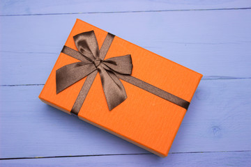 orange gift box on a purple wooden background