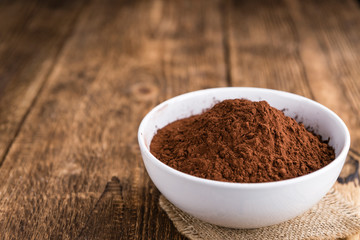 Cocoa powder on wooden background