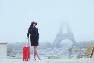 tourist in Paris, Europe tour, woman with luggage near Eiffel Tower, France