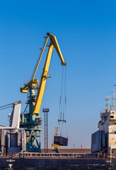 Fototapeta na wymiar Cargo crane lifting container, Saint-Petersburg, Russia