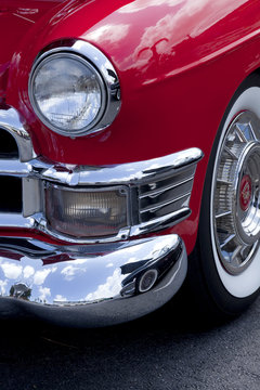 Closeup of a front classic red roaster car finder and headlight