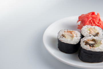 Closeup of three sushi rolls on small plate and a lot of place for text