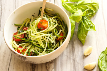 Zucchini pasta noodles with dressing in a white bowl