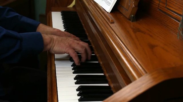 Older Male Hands Playing Slow Song On Upright Piano From The Side
