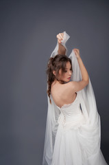 Fototapeta premium Bride in white wedding gown posing with veil