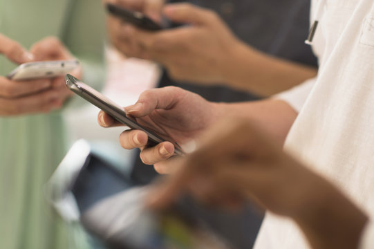 Close-up of hands texting on cell phones