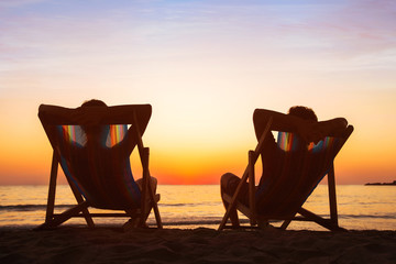 enjoy life concept, couple relaxing in beach hotel  at sunset, happy people on honeymoon, paradise...