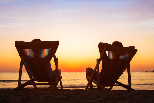 Enjoy Life Concept, Couple Relaxing In Beach Hotel  At Sunset, Happy People On Honeymoon, Paradise Travel Destination