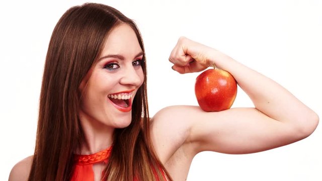 Woman fit girl holds apple fruit on her biceps arm 4K