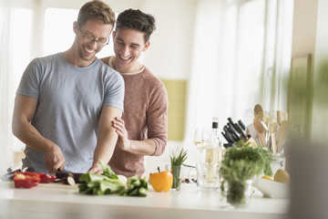 Caucasian gay couple cooking in kitchen