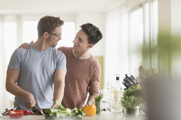Caucasian gay couple cooking in kitchen