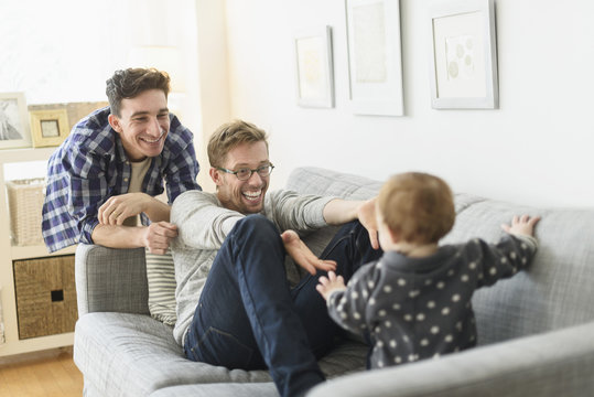 Fathers and baby relaxing on sofa at home