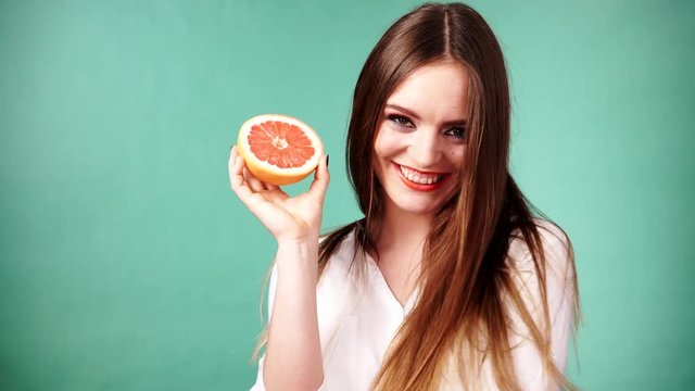 Woman holds half of grapefruit citrus fruit in hand 4K