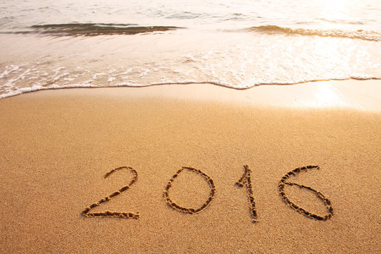 new year 2016 concept, text written on the sand of beach