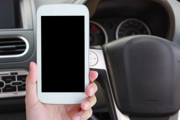 hand hold mobile phone with car steering wheel background