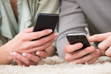 Close-up Of Couple Holding Cellphones