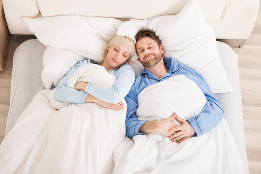 Young Couple Sleeping On Bed