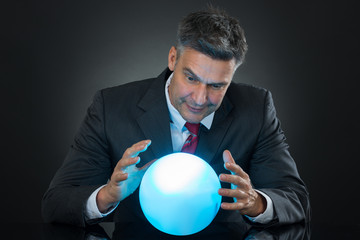 Portrait Of Businessman Predicting Future With Crystal Ball