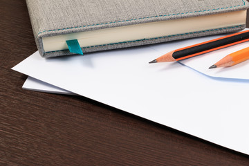 White envelopes and notebook with pencil on wooden table.