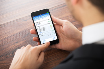 Businessman Doing Online Banking On Mobile Phone