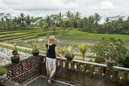 Caucasian woman admiring rural farm fields from rooftop