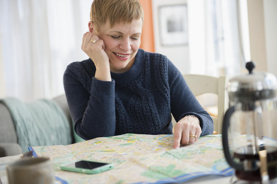 Caucasian woman reading map at table