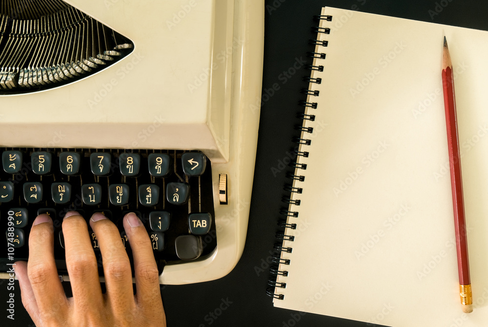 Fototapete old typewriter and notebook on black table background