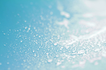 Close up rain water drops on blue sponge surface 