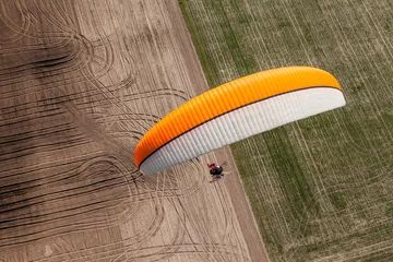 Photo sur Plexiglas Sports aériens aerial view of paramotor flying over the fields