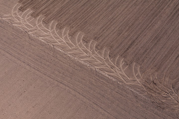 Naklejka premium aerial view of tractor tracks on harvest field