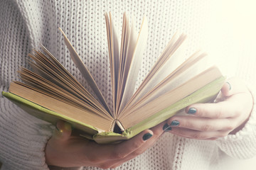 Young girle reading an  open book . old book. Books and reading are essential for self improvement,...