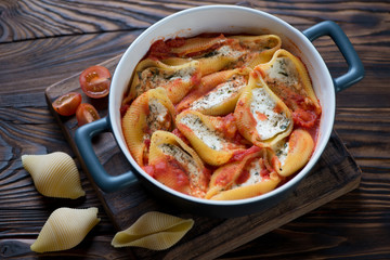 Baked conchiglione with cottage cheese and tomato sauce, closeup