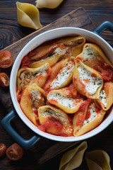 Top view of conchiglioni baked with cottage cheese, close-up