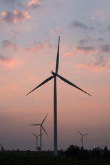 silhouette of wind turbines at sunset