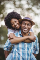 Handsome man giving piggy back to his girlfriend