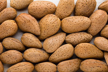 Group of almond nuts with leaves.Wooden background.