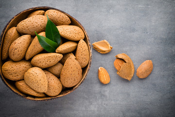 Group of almond nuts with leaves.Wooden background.