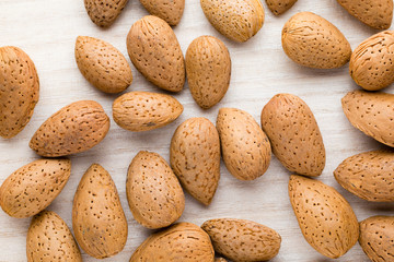 Group of almond nuts with leaves.Wooden background.