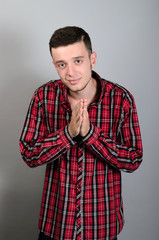 Fototapeta premium picture of a casual young man standing with his palms together