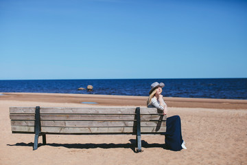 girl sitting on a bench on the beach