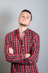 Portrait of young angry man on gray background