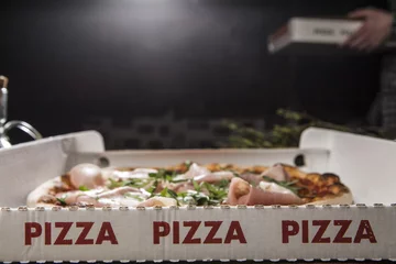 Photo sur Plexiglas Pizzeria 3 scritte rosse Pizza  in cartone da asporto con pizza farcita all'interno