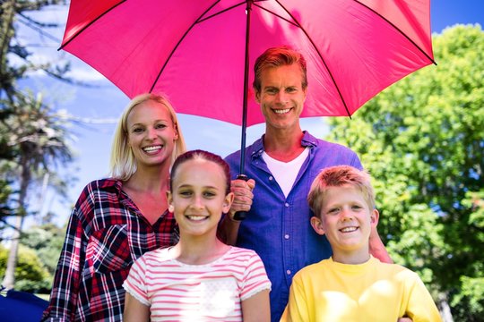 Family standing under umbrella