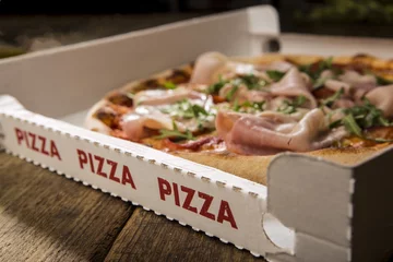 Foto auf Acrylglas Pizzeria Pizza Pappdetail mit Schriftzug und Pizza, die man sehen kann