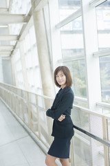 Attractive asian business woman smiling outside office