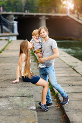 Obraz premium A young and happy family relaxing in the park with his young son