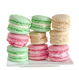 Multi colored sweet macaroons, french traditional, cream, white plate, close up, isolated on a white background